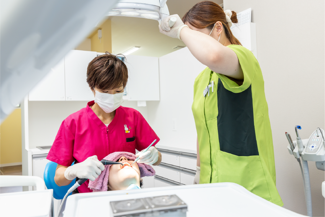 笑顔で話す歯科衛生士